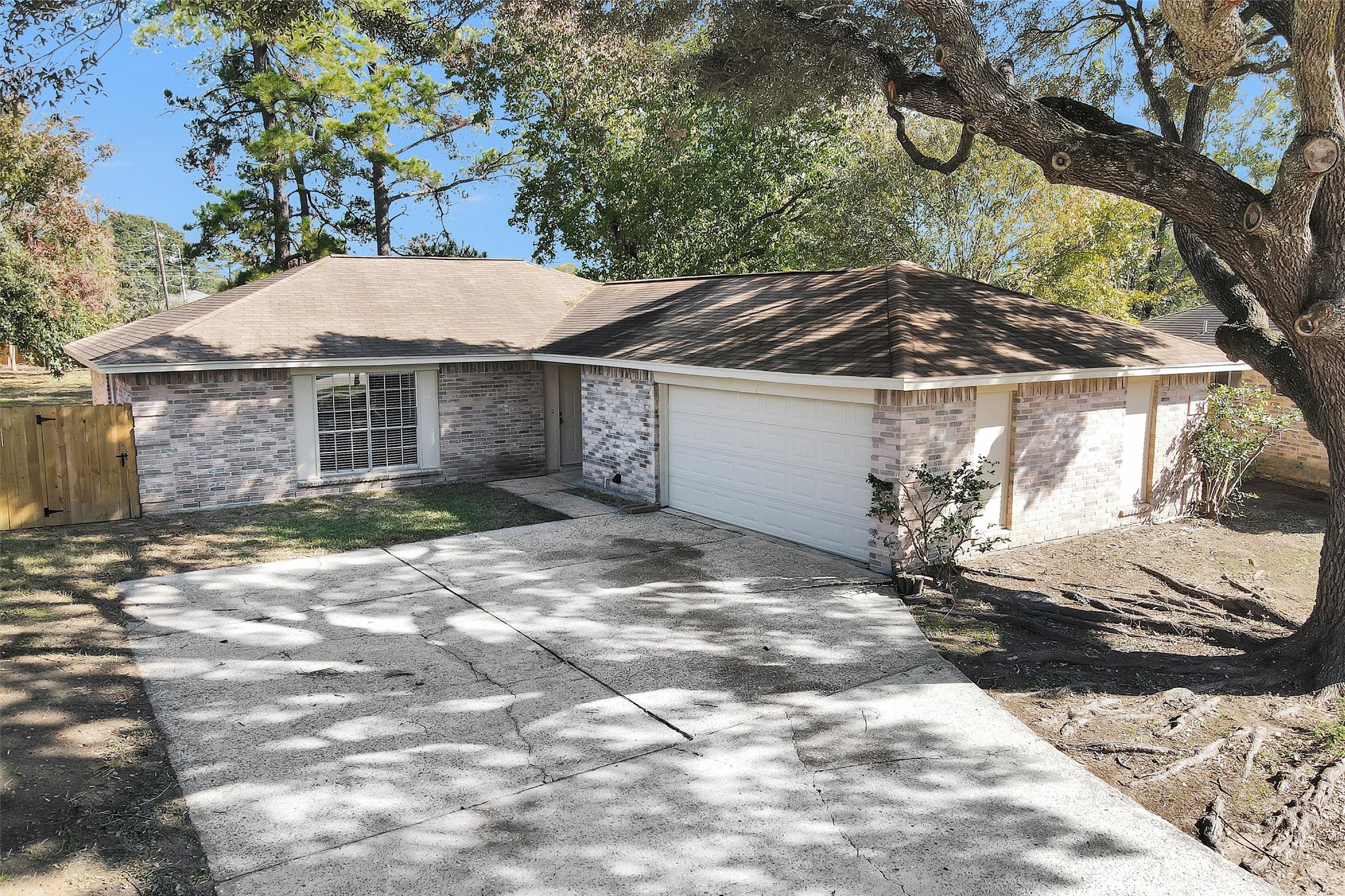 21030 Rivershadows Lane Spring, TX 77388 - Photo 33 of 38 a view of a white house with a large tree and wooden fence