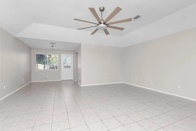 an empty room with windows and fan