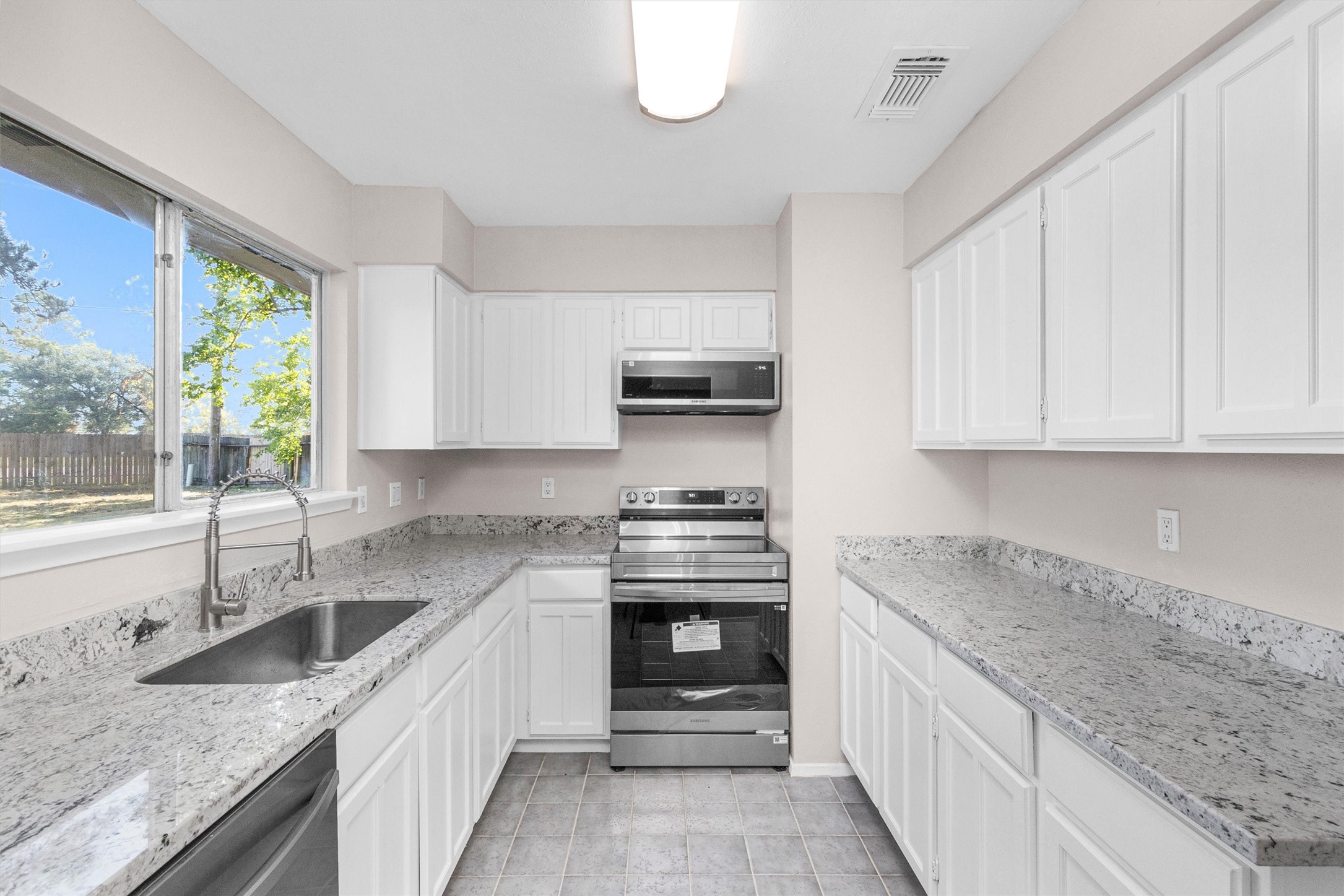 21030 Rivershadows Lane Spring, TX 77388 - Photo 9 of 38 a kitchen with granite countertop a sink stove and cabinets