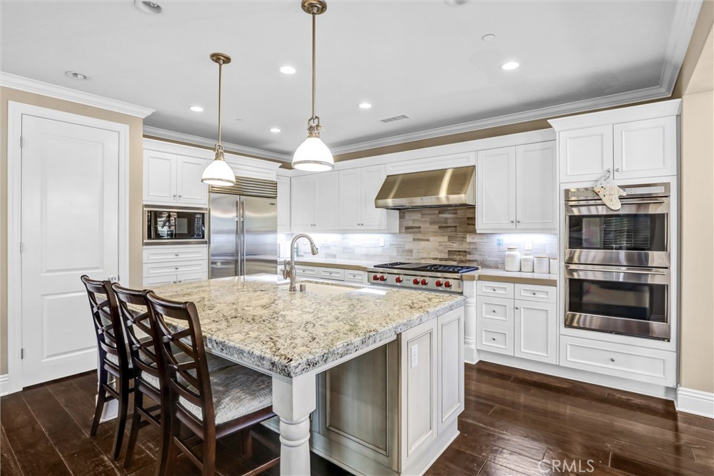 59 Rossmore Irvine, CA 92620 - Photo 15 of 45 a kitchen with stainless steel appliances granite countertop a stove top oven a sink dishwasher a dining table and chairs