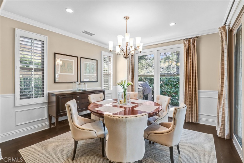 59 Rossmore Irvine, CA 92620 - Photo 16 of 45 a dining room with furniture a chandelier and wooden floor