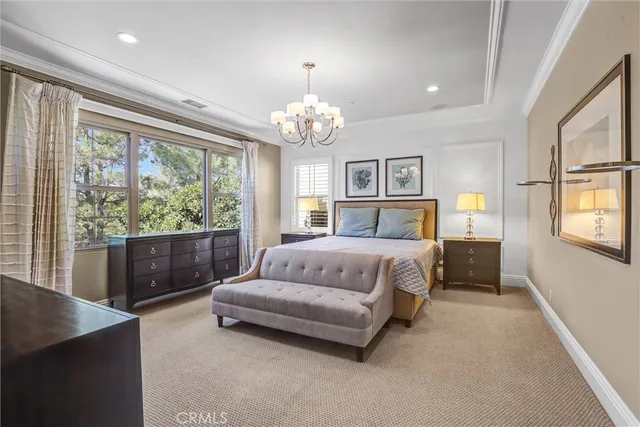 a bedroom with a large bed and a chandelier