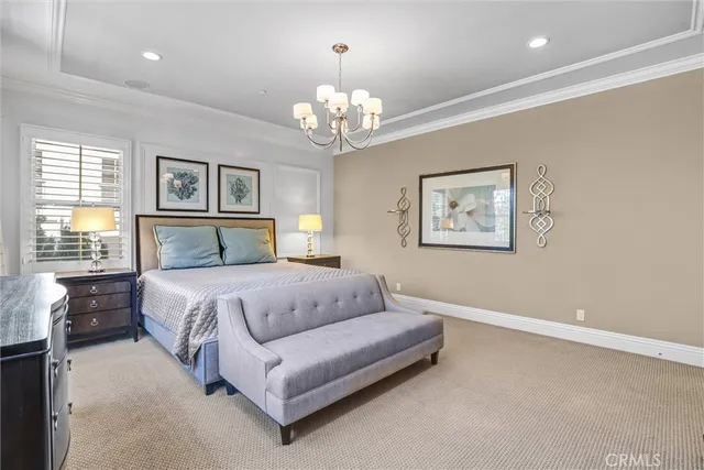 a spacious bedroom with a bed and a chandelier