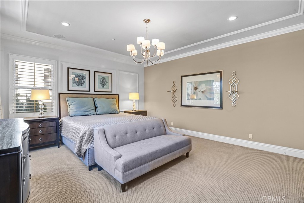 59 Rossmore Irvine, CA 92620 - Photo 22 of 45 a spacious bedroom with a bed and a chandelier