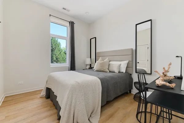 a bedroom with a bed table and chair