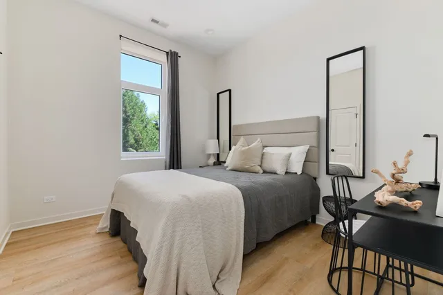 a bedroom with a bed table and chair