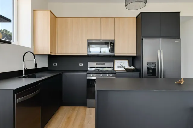 a kitchen with kitchen island granite countertop a sink stove and refrigerator