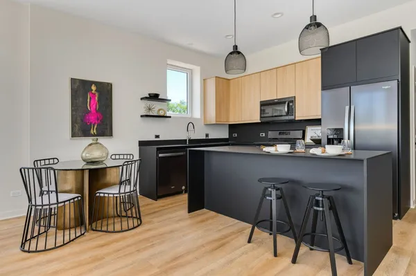 a kitchen with stainless steel appliances granite countertop a sink dishwasher a stove refrigerator and cabinets with wooden floor