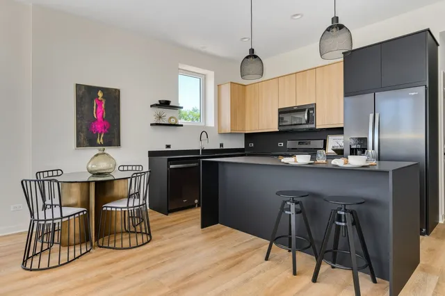 a kitchen with stainless steel appliances granite countertop a sink dishwasher a stove refrigerator and cabinets with wooden floor