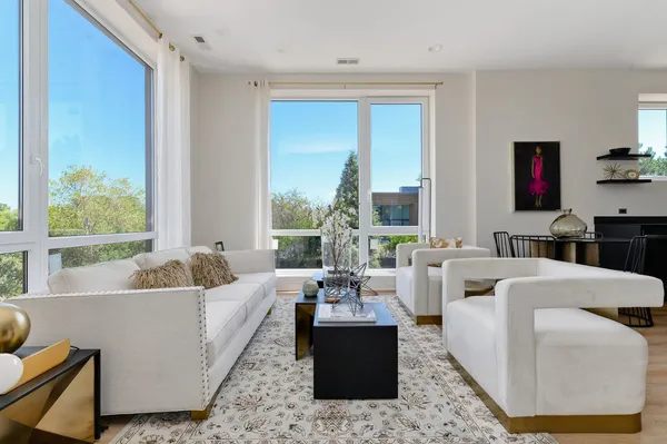 a living room with furniture fireplace and a large window