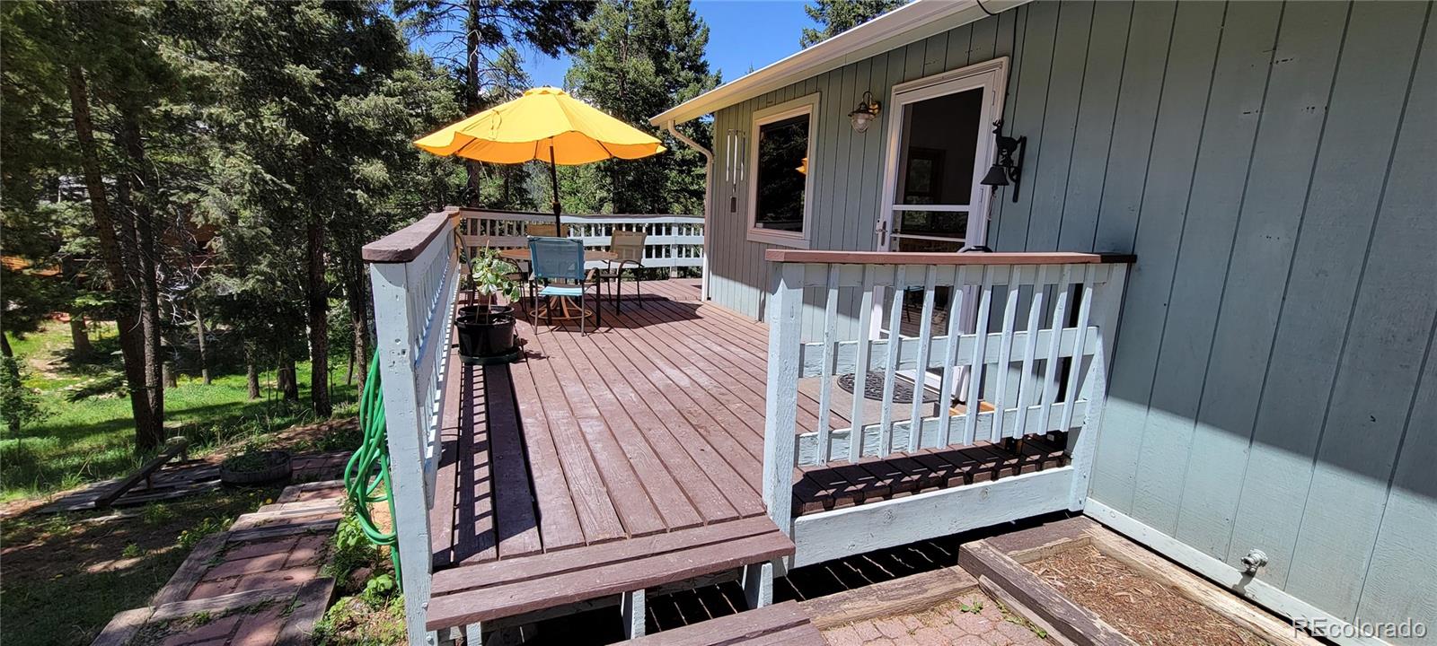 19533 Silver Ranch Road Conifer, CO 80433 - Photo 4 of 19 a view of a wooden deck with a yard