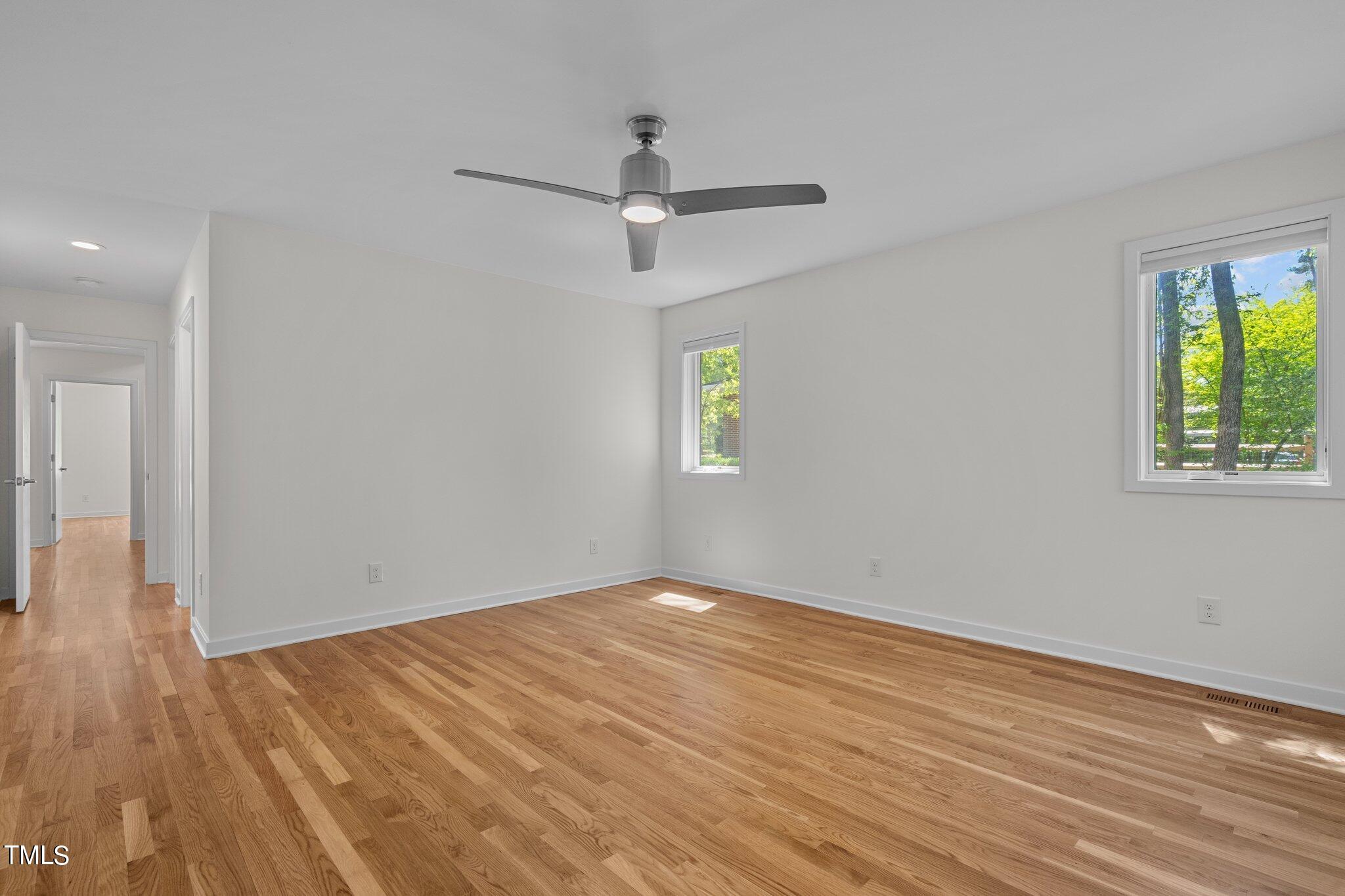 3546 Dixon Road Durham, NC 27707 - Photo 9 of 16 an empty room with wooden floor ceiling fan and windows