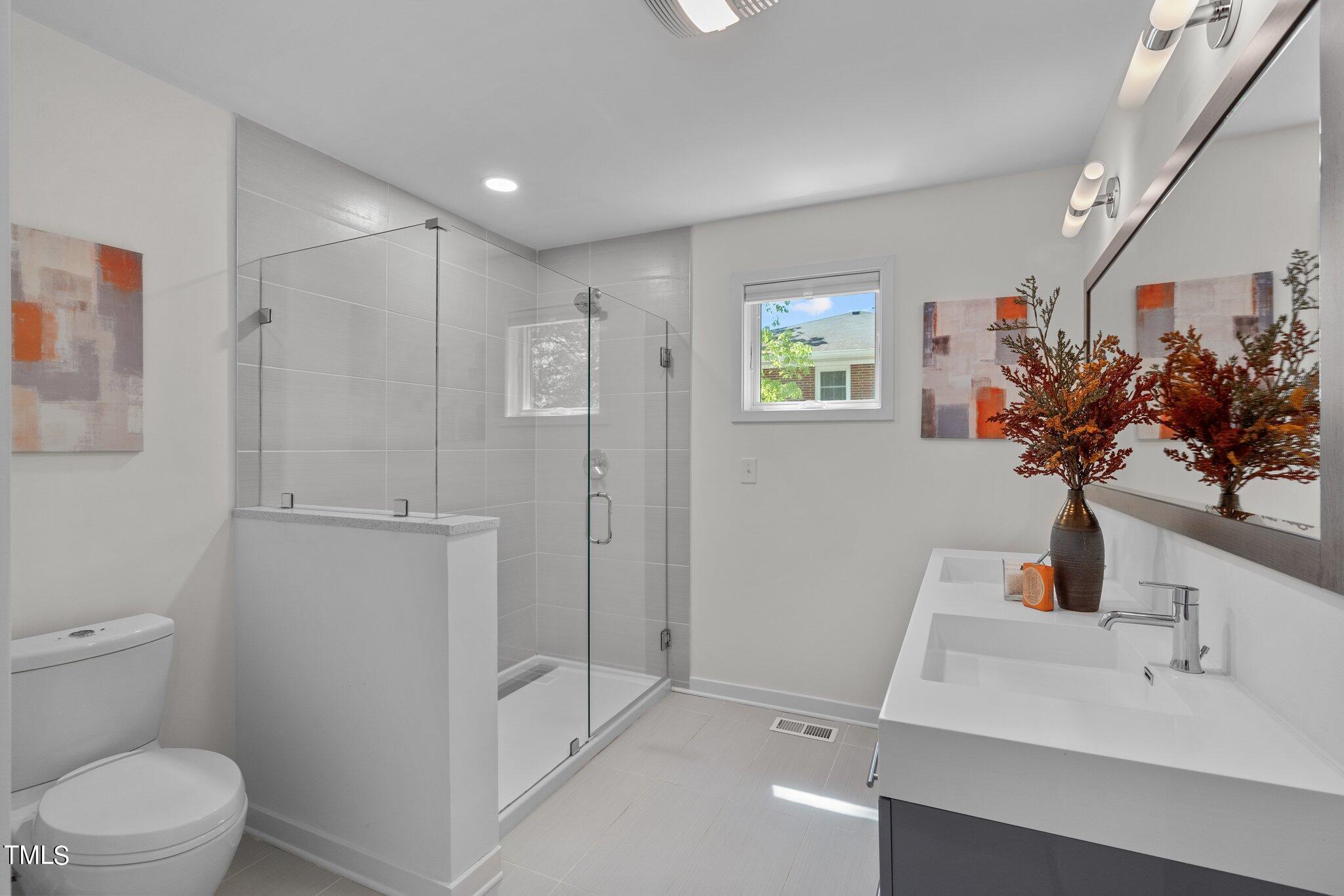 3546 Dixon Road Durham, NC 27707 - Photo 10 of 16 a bathroom with a sink mirror vanity and toilet