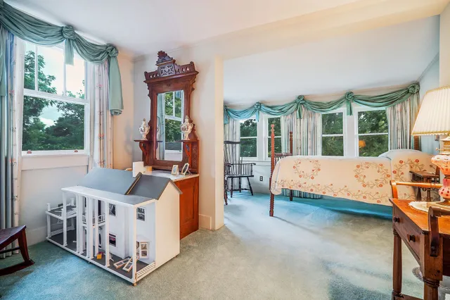 a bedroom with a bed and large windows