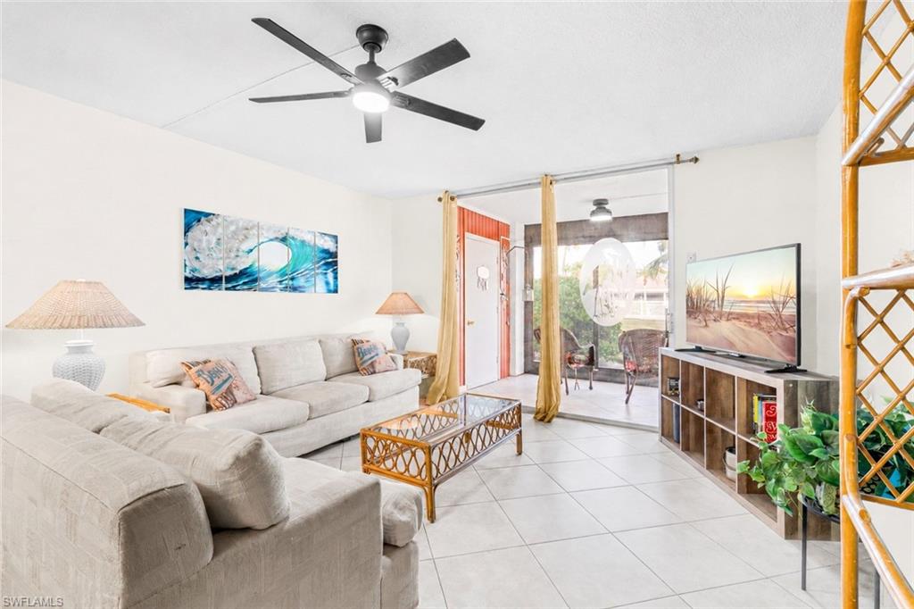 5959 Winkler Road, Unit 114 Fort Myers, FL 33919 - Photo 1 of 20 a living room with furniture a flat screen tv and a large window