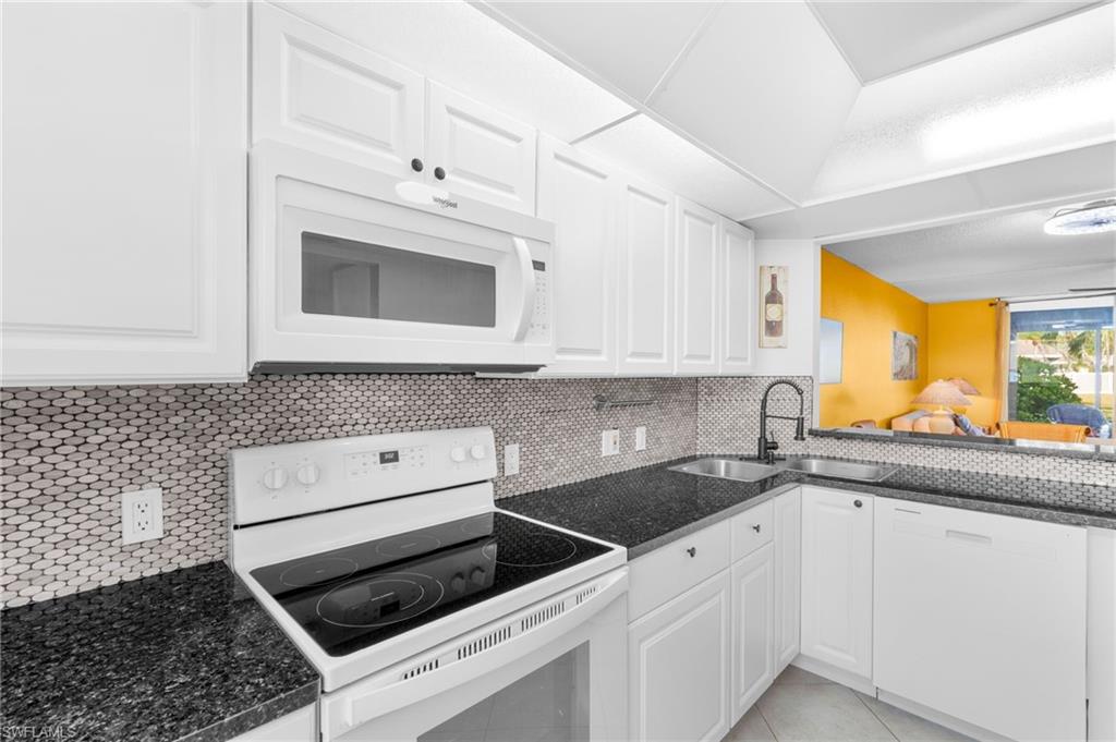 5959 Winkler Road, Unit 114 Fort Myers, FL 33919 - Photo 8 of 20 a kitchen with granite countertop white cabinets and white appliances