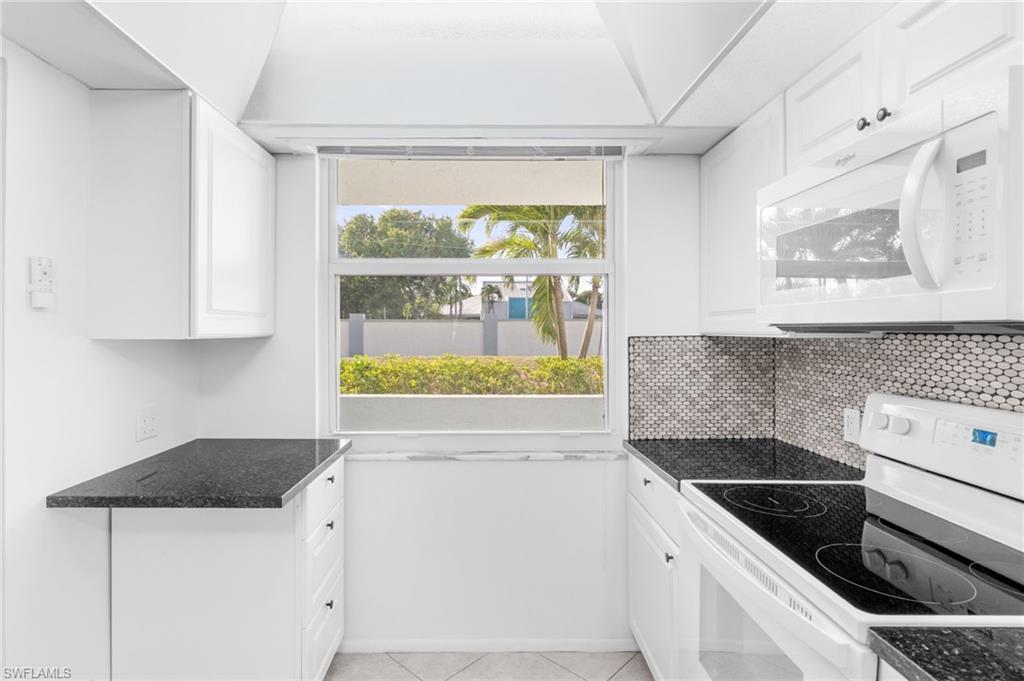5959 Winkler Road, Unit 114 Fort Myers, FL 33919 - Photo 9 of 20 a kitchen with a stove and a white refrigerator