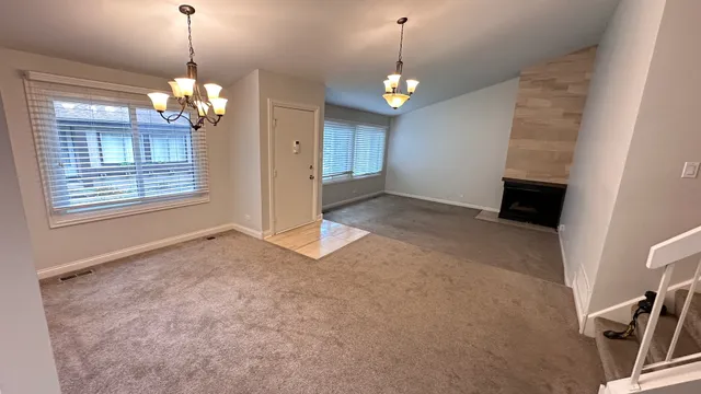 a view of livingroom with chandelier fan and kitchen view