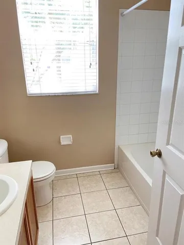 a bathroom with a granite countertop sink a toilet and bathtub