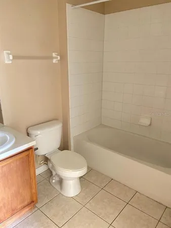 a white toilet sitting next to a bath tub and a shower