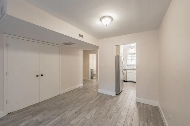 a view of empty room with wooden floor