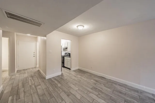 a view of an empty room with wooden floor