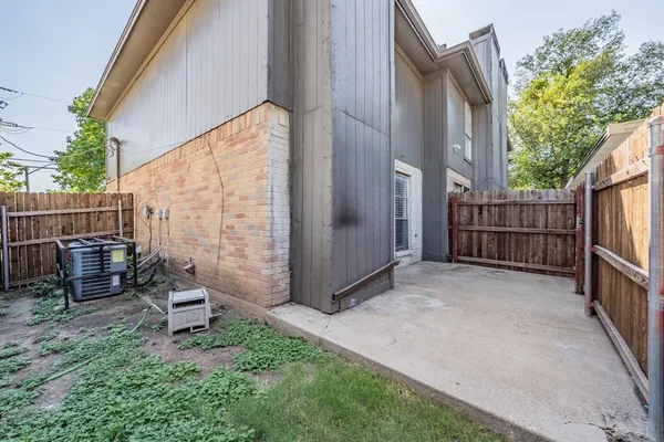 a view of a backyard with wooden fence and a bench