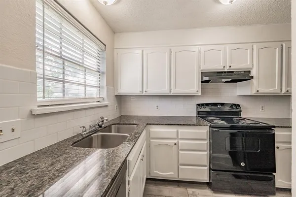 a kitchen with stainless steel appliances granite countertop a sink stove and cabinets