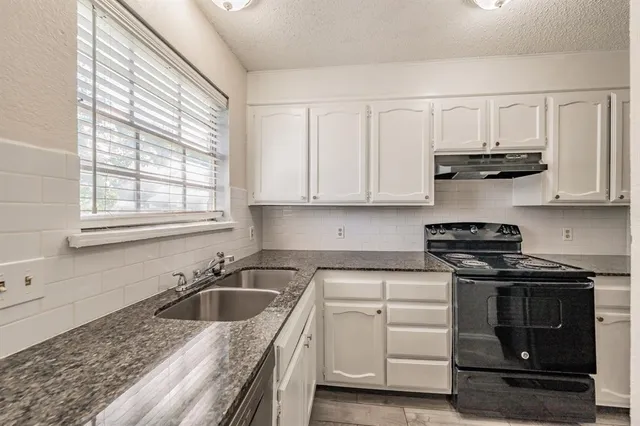 a kitchen with stainless steel appliances granite countertop a sink stove and cabinets