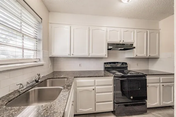 a kitchen with stainless steel appliances granite countertop a sink stove and cabinets
