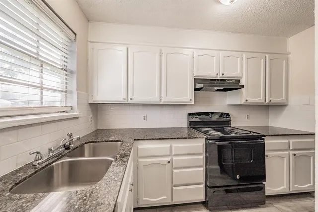 a kitchen with stainless steel appliances granite countertop a sink stove and cabinets