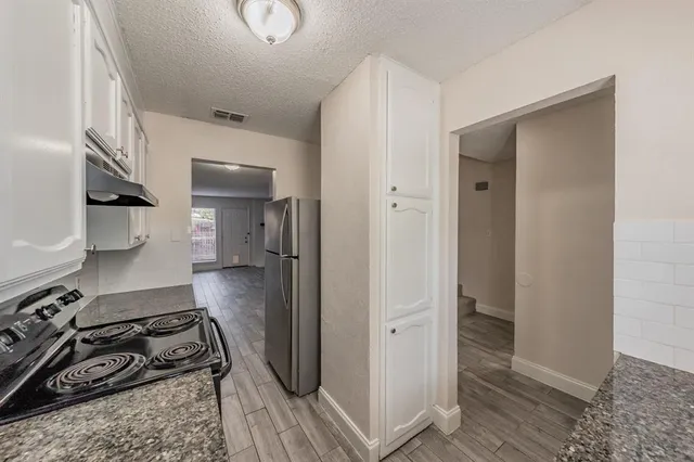 a walk in closet and view of living room