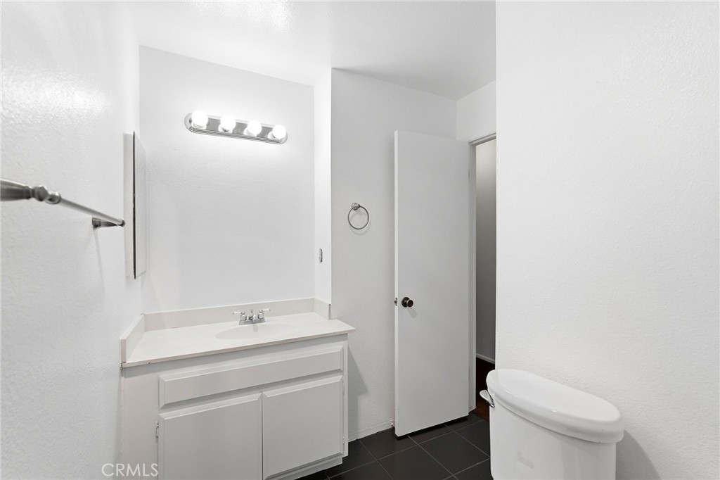 7890 East Spring Street, Unit 11E Long Beach, CA 90815 - Photo 24 of 40 a bathroom with a sink a toilet and shower