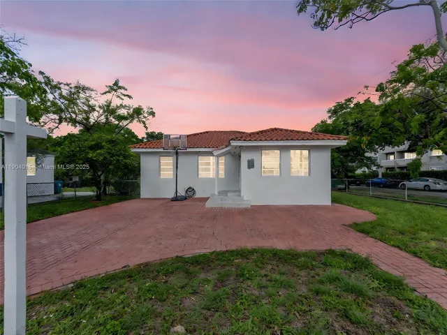 a view of a house with a yard and a tree