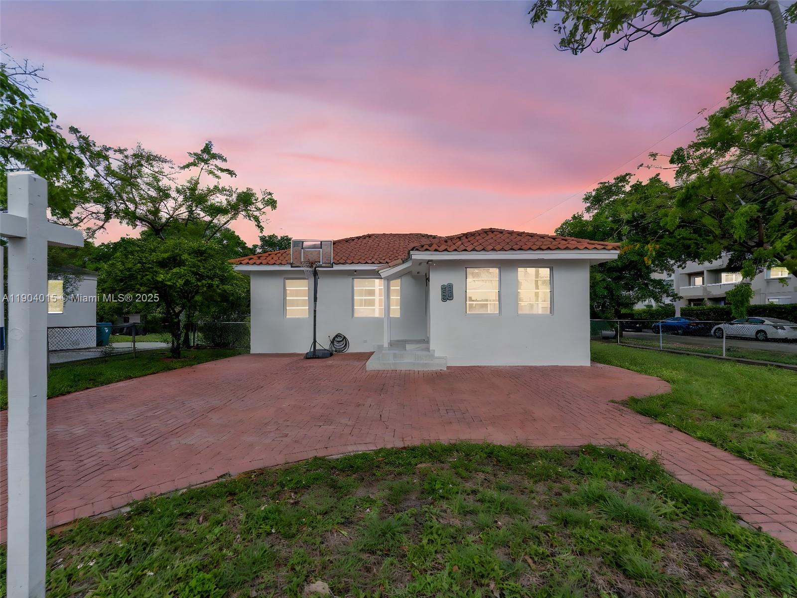 a view of a house with a yard and a tree
