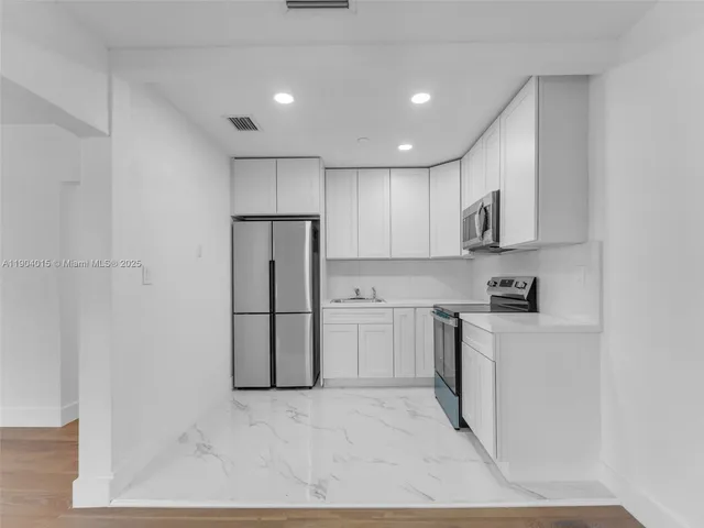 an empty room with wooden floor ceiling fan and windows