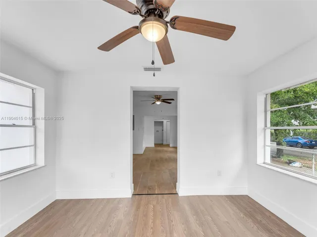 a view of a room with wooden floor fan and window