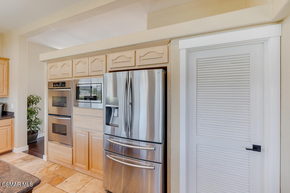 6500 Meadowglade Drive Moorpark, CA 93021 - Photo 53 of 64 a metallic refrigerator freezer and a stove sitting inside of a kitchen