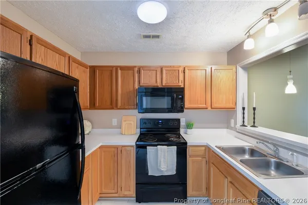 a kitchen with stainless steel appliances granite countertop a sink stove and microwave