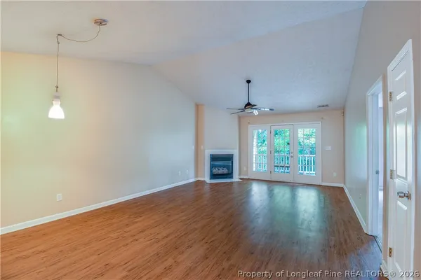 a view of an empty room with a fireplace and a window