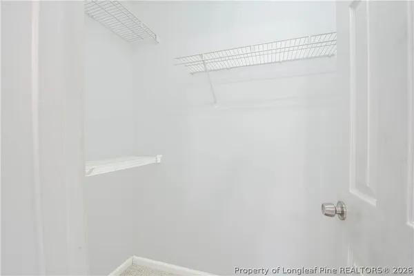 a view of an empty room with glass door and a bathroom