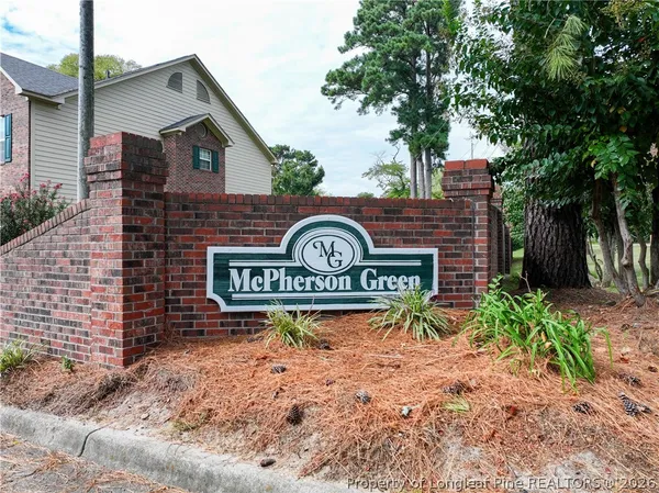 a view of a street sign under a large tree