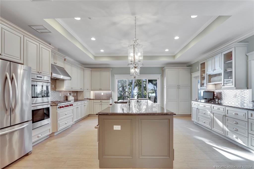 51 North River Road Stuart, FL 34996 - Photo 13 of 59 a kitchen with stainless steel appliances granite countertop a refrigerator a sink dishwasher a stove and white cabinets