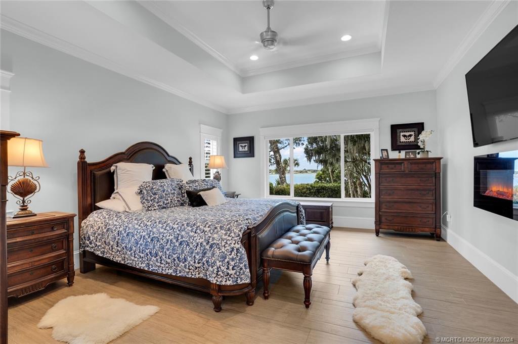 51 North River Road Stuart, FL 34996 - Photo 19 of 59 a bedroom with a bed couches and a flat tv screen