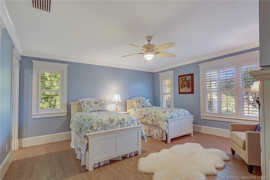 51 North River Road Stuart, FL 34996 - Photo 27 of 59 a spacious bedroom with two beds and a chandelier