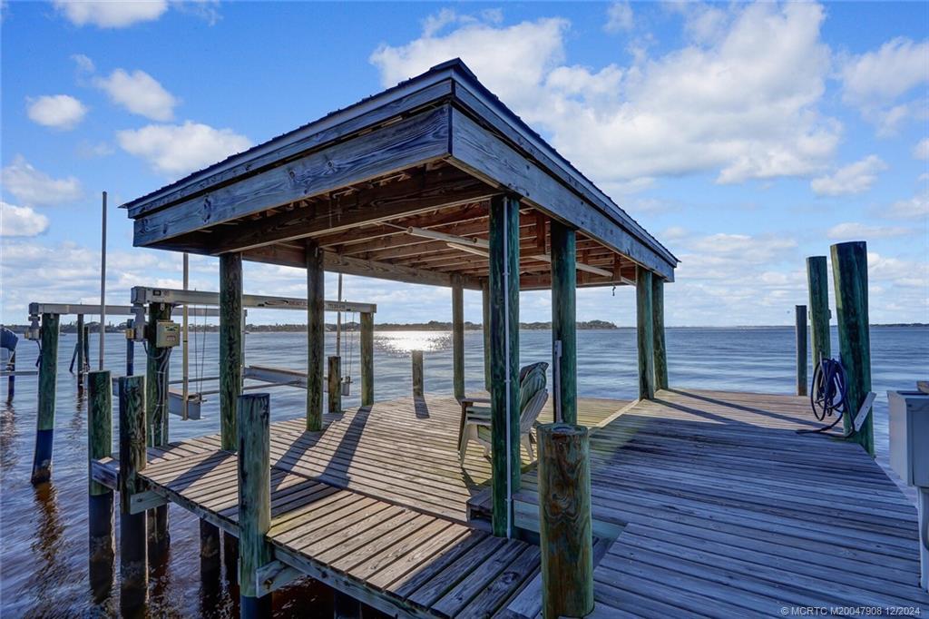 51 North River Road Stuart, FL 34996 - Photo 46 of 59 a roof deck with table and chairs a barbeque with wooden floor and fence