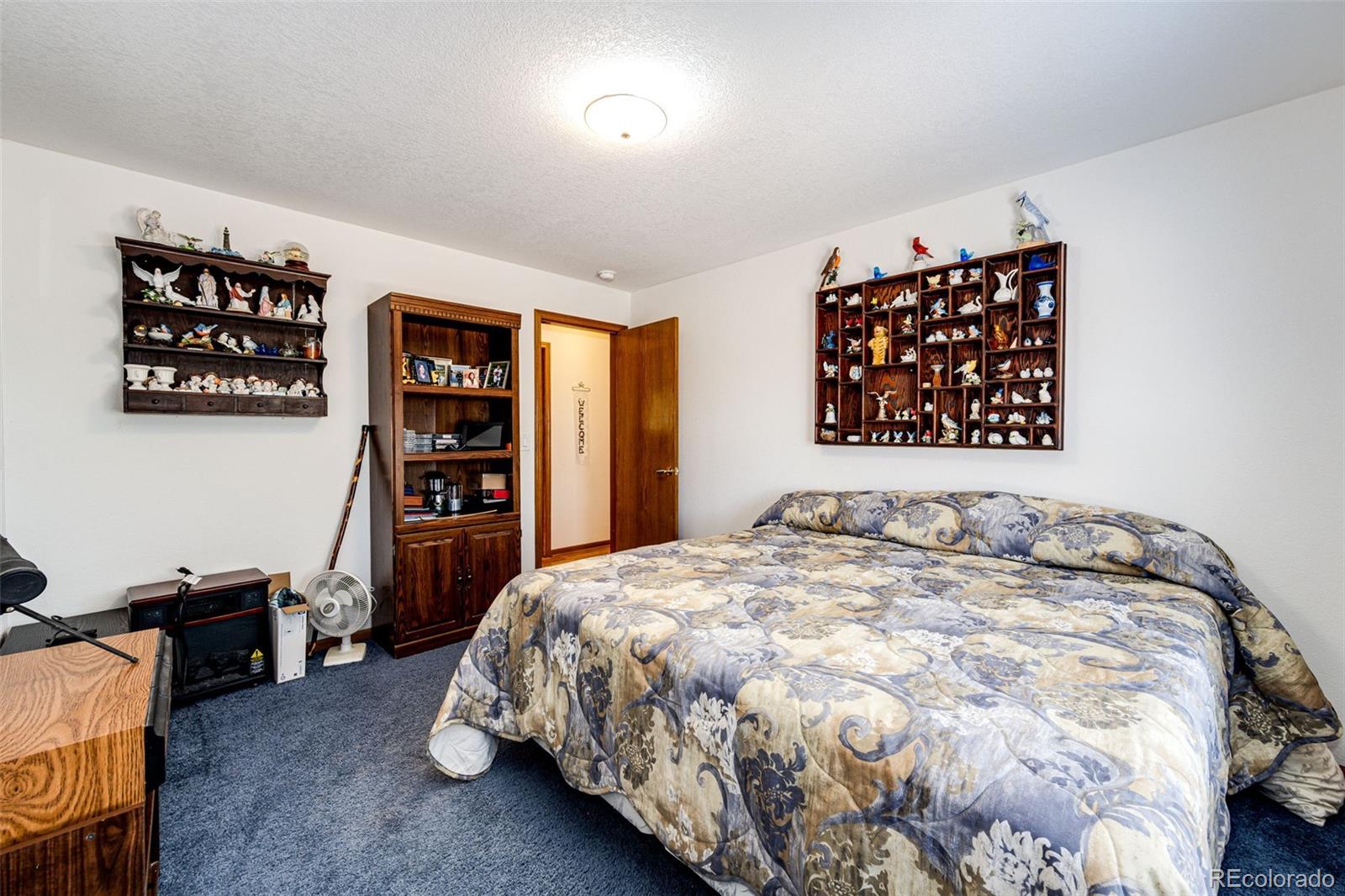 4420 Behrens Road Byers, CO 80103 - Photo 12 of 39 a bedroom with a bed and a book shelf