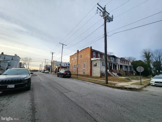 a view of a city street with a car parked on the road