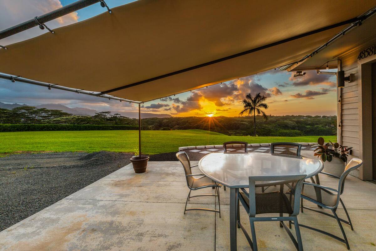 4858 Kahiliholo Road, Unit #3 Kilauea, HI 96754 - Photo 11 of 22 a backyard of a house with table and chairs