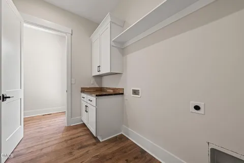 a room with a white cabinets and wooden floor